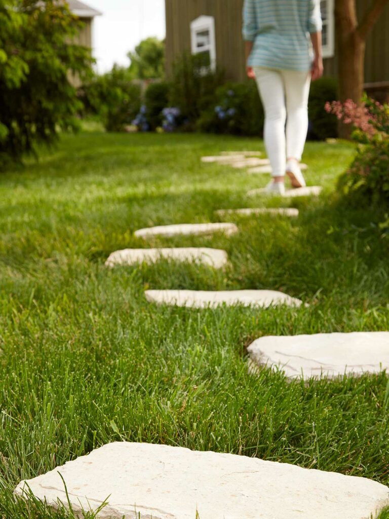 woman walking across yard pavers